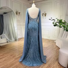 The mesmerizing blue hue exudes elegance and sophistication, perfect for formal events. Mermaid silhouette gracefully accentuates curves, offering a flattering and glamorous fit. Featuring cape sleeves, adding a touch of drama and sophistication to the ensemble. Embellished with luxurious beadwork and feathers, adding texture and glamour to the gown. Ideal for evening parties and special occasions, ensuring a captivating presence with refined luxury and style. Elegant Cape, Beaded Feather, Blue Mermaid, Cape Sleeves, Dress 2024, Mermaid Silhouette, Ladies Party, Blue Hues, Formal Event