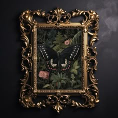 an ornate gold frame with a butterfly and flowers in the center on a black wall