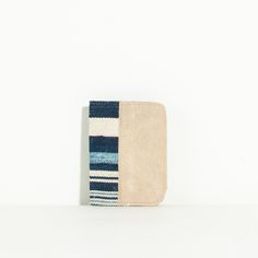 a small wallet with a striped pattern on it's front and back sides, sitting against a white background