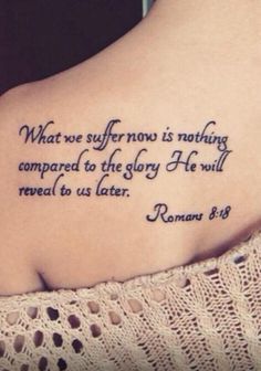 the back of a woman's shoulder with a bible verse on it