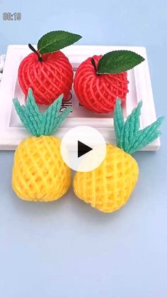 two pineapples and one strawberry on a plate