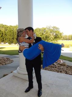 a man in a tuxedo hugging a woman