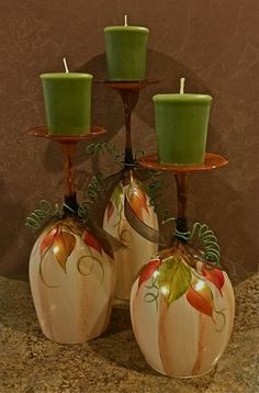 three pumpkin shaped candle holders with candles on them