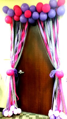 the door is decorated with balloons and streamers