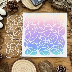 a card with circles on it next to some wood slices and pineconi cones