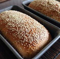 two loafs of bread sitting on top of a cooling rack next to each other