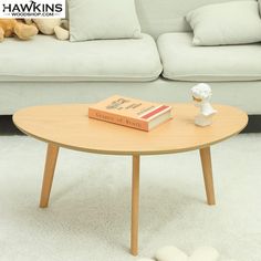 a coffee table with a book on it in front of a couch and teddy bear