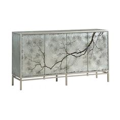 a mirrored cabinet with branches painted on the front and side panels in silver, black and white