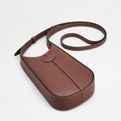 Expertly crafted in calfskin leather, the Di Hobo Micro Bag by Tod's is both stylish and versatile. With its central ribbing and oval Tod's logo, it can double as a phone holder accessory. Complete with an adjustable shoulder strap, this bag is a must-have for any fashion-forward individual. Designer Leather Baguette Bag For Mobile Phone, Classic Leather Phone Bag With Adjustable Strap, Luxury Leather Phone Bag With Adjustable Strap, Modern Leather Baguette Bag For Mobile Phones, Modern Leather Baguette Bag With Mobile Phone Holder, Classic Leather Phone Bag With Detachable Strap, Classic Leather Crossbody Phone Bag, Classic Leather Phone Bag With Removable Pouch, Formal Leather Baguette Bag For Mobile Phone