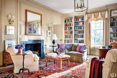 a living room filled with furniture and bookshelves next to a fire place in front of a fireplace