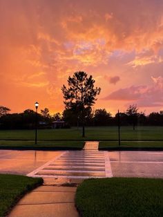 the sun is setting over a park with water running down it's walkways