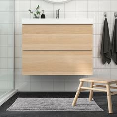 a bathroom with a sink, mirror and wooden stool