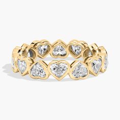 a yellow gold ring with heart shaped diamonds on the sides and two rows of hearts in the middle