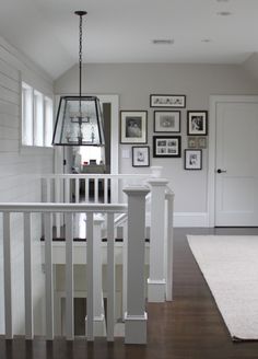 a white staircase with pictures on the wall