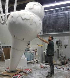 a man standing next to a large white sculpture