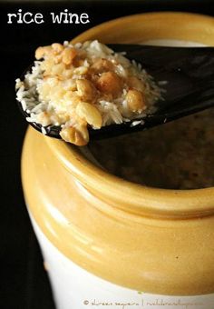 a spoon full of rice and nuts in a jar with the words rice wine on it