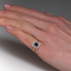 This lovely vintage ring is centered with one (1) emerald cut natural sapphire set into a bezel and is bordered with eighteen (18), bead set, rose cut diamonds. The ring measures 11.5mm at the top, rises 3.6mm above the finger, tapering to 2.1mm wide and 0.9mm thick at the base of the shank. This ring is currently a size 5.25. The sapphire shows abrasions. Emerald Cut Sapphire Rings With 17 Jewels, Radiant Cut Yellow Gold Sapphire Ring, Fine Jewelry Ring With Square Cut Rose Diamonds, Emerald Cut Sapphire Jewelry With Rose Cut Diamonds, Emerald Cut Sapphire Ring With Rose Cut Diamonds, Elegant Baguette Cut Sapphire Ring With Bezel Setting, Formal Sapphire Ring With Bezel Set Emerald Cut, Square Cut Sapphire Ring Fine Jewelry, Formal Sapphire Ring With Emerald Cut