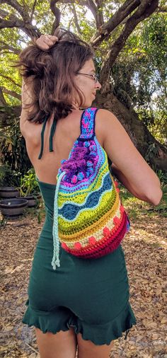 a woman carrying a colorful crochet bag on her back