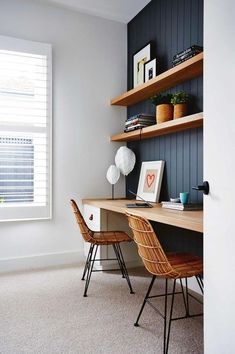 a desk with two chairs in front of it and shelves on the wall behind it