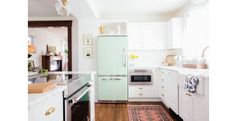 a kitchen with white cabinets and light green refrigerator freezer next to stove top oven