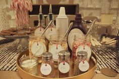 mason jars filled with candy canes on a tray next to cookies and candies