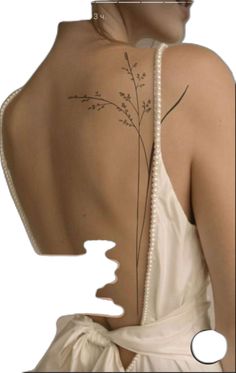 the back of a woman's dress with flowers on her shoulder and behind it is a piece of paper that has been cut out