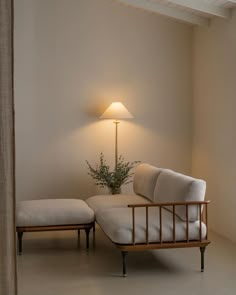 a white couch sitting next to a lamp on top of a wooden table in a living room