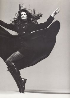 black and white photograph of a woman with long hair in mid - air, dancing