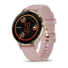 the garmin watch is shown in pink with gold accents and an orange circle on its face