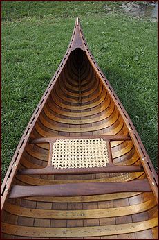 a wooden canoe sitting in the grass