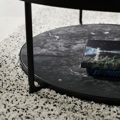 a book sitting on top of a black table next to a white carpeted floor