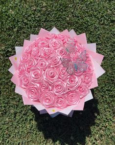 a bouquet of pink roses with a butterfly on top