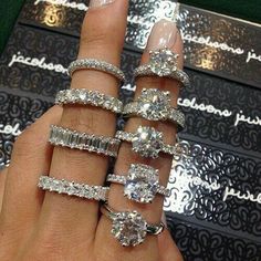 someone is showing off their wedding rings and engagement bands, which are set on top of each other