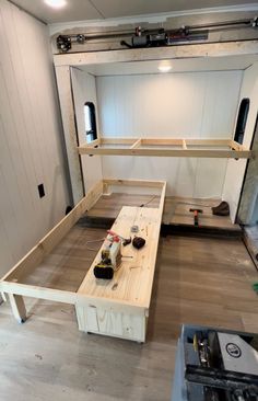 a room that is being built with wood and some tools on the table in front of it