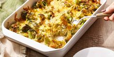 a casserole dish with broccoli and cheese being spooned into it