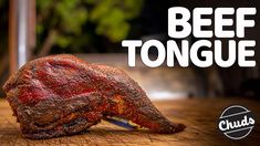 a piece of beef on a cutting board with the words beef tongue