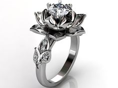 a gold and silver ring with a flower on the front, surrounded by diamonds in the middle