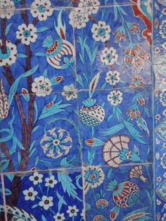 an artisticly painted tile wall with flowers and birds in blue, red, white and orange colors