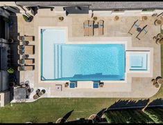 an aerial view of a swimming pool and lounge chairs