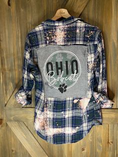 Artfully distressed, upcycled and sustainable flannel shirt paired with upcycled tee with graphic.  Unisex in style but sourced from a variety of brands so resized for a roomy women's fit.  All one of kind and unless noted, flannel is medium weight.  Show your pride with a unique spirit wear  that only you will have. Plaid Cotton Tops With Letter Print, Casual Flannel Patchwork Top, Casual Flannel Top With Patchwork, Distressed Relaxed Fit Shirt For Fall, Casual Bleached Cotton Shirt, Casual Distressed Shirt For Fall, Vintage Flannel Top With Graphic Print, Fall Cotton Flannel Shirt With Graphic Print, Fall Flannel Top With Graphic Print