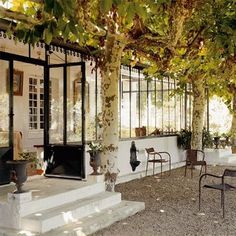 an outdoor patio with chairs and tables under trees