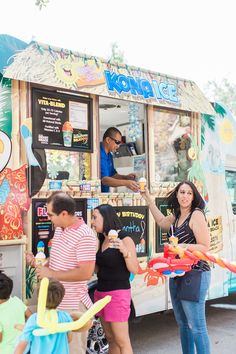 a group of people standing in front of a food truck with an ice cream vendor