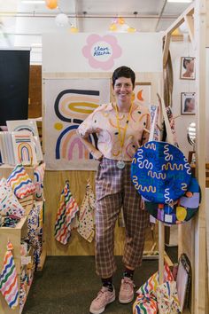 a man standing in front of a display of kites and other items for sale