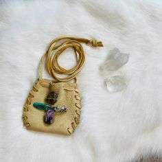 a white fur with a gold leather purse and some crystal beads on it's side