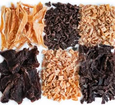 four different types of dried fruit on a white surface