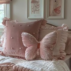 a bed topped with lots of pink pillows