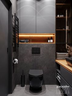 a black toilet sitting in a bathroom next to a cabinet