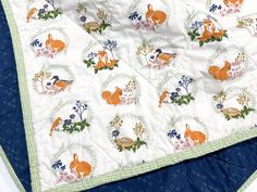 an image of a quilted blanket with animals and flowers on it's edges