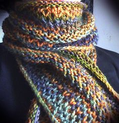 a multicolored knitted scarf on top of a black shirt