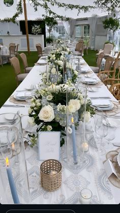 the table is set with white flowers and candles for an elegant dinner or reception party